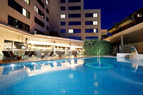 Una piscina al aire libre de temporada, sillones reclinables de piscina