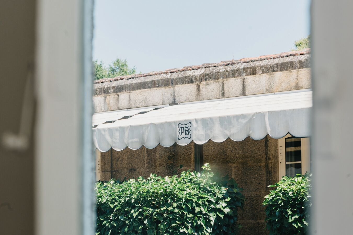 Un edificio con toldo blanco y un letrero con la letra 'P'.