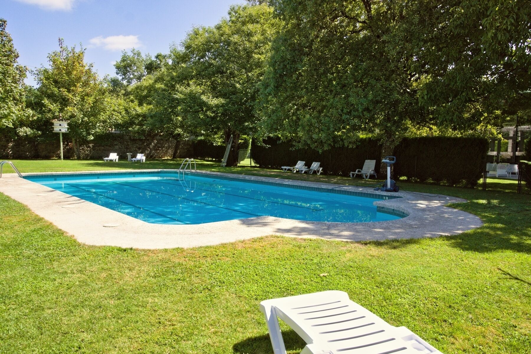 Una piscina al aire libre de temporada, tumbonas