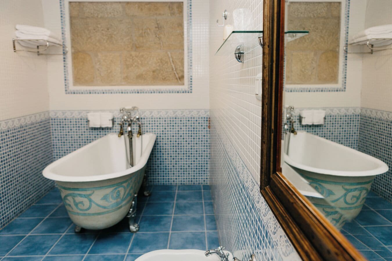 Un bany amb una banyera autònoma, un lavabo i un mirall.