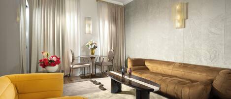 Un salon moderne comprenant un canapé, des fauteuils, une table basse et un coin repas avec des chaises et une table.