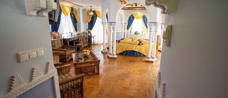 A room with a bed, wooden furniture, and decorative arches.
