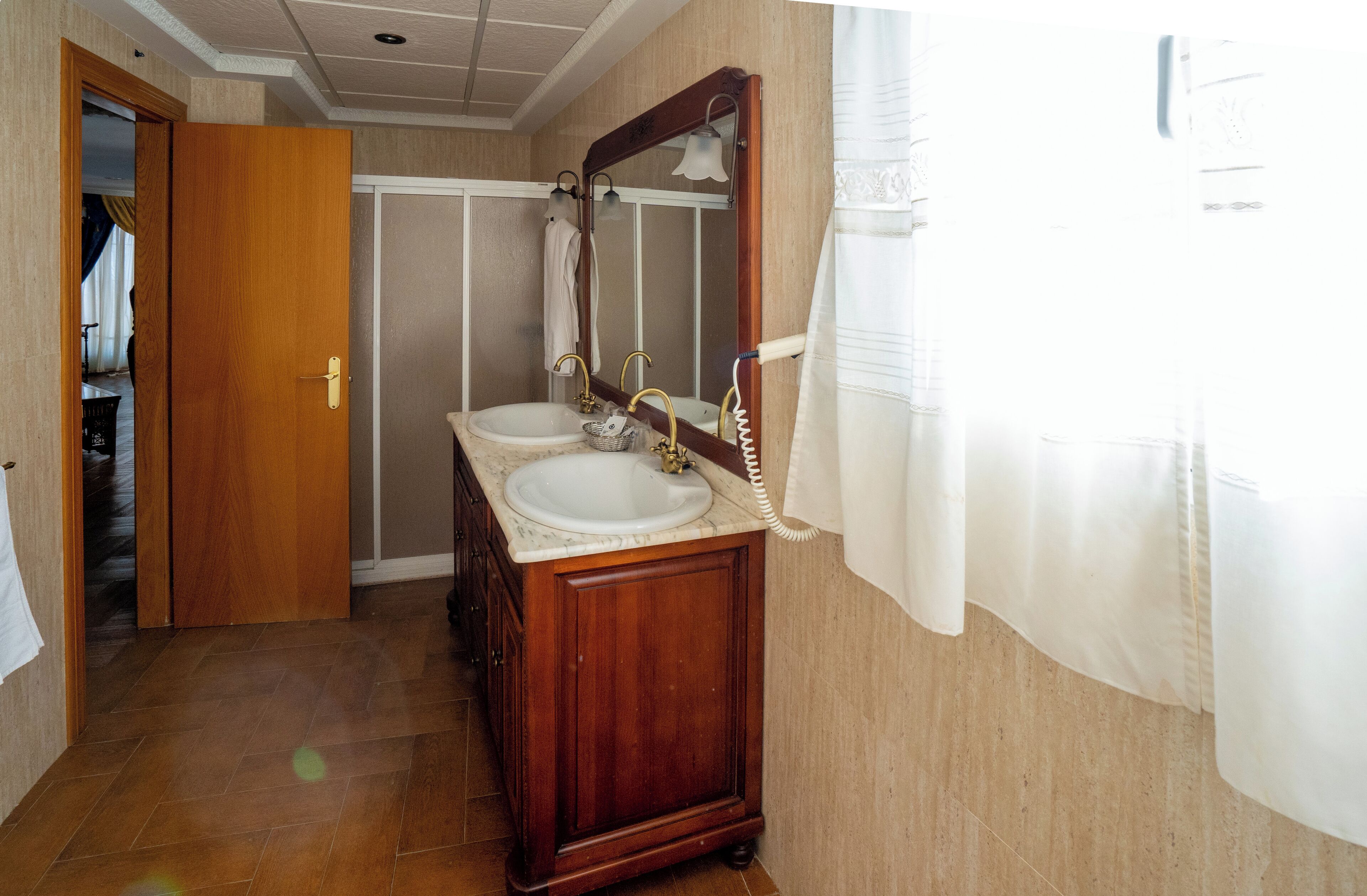 A bathroom with two sinks, a mirror, and a wooden cabinet.