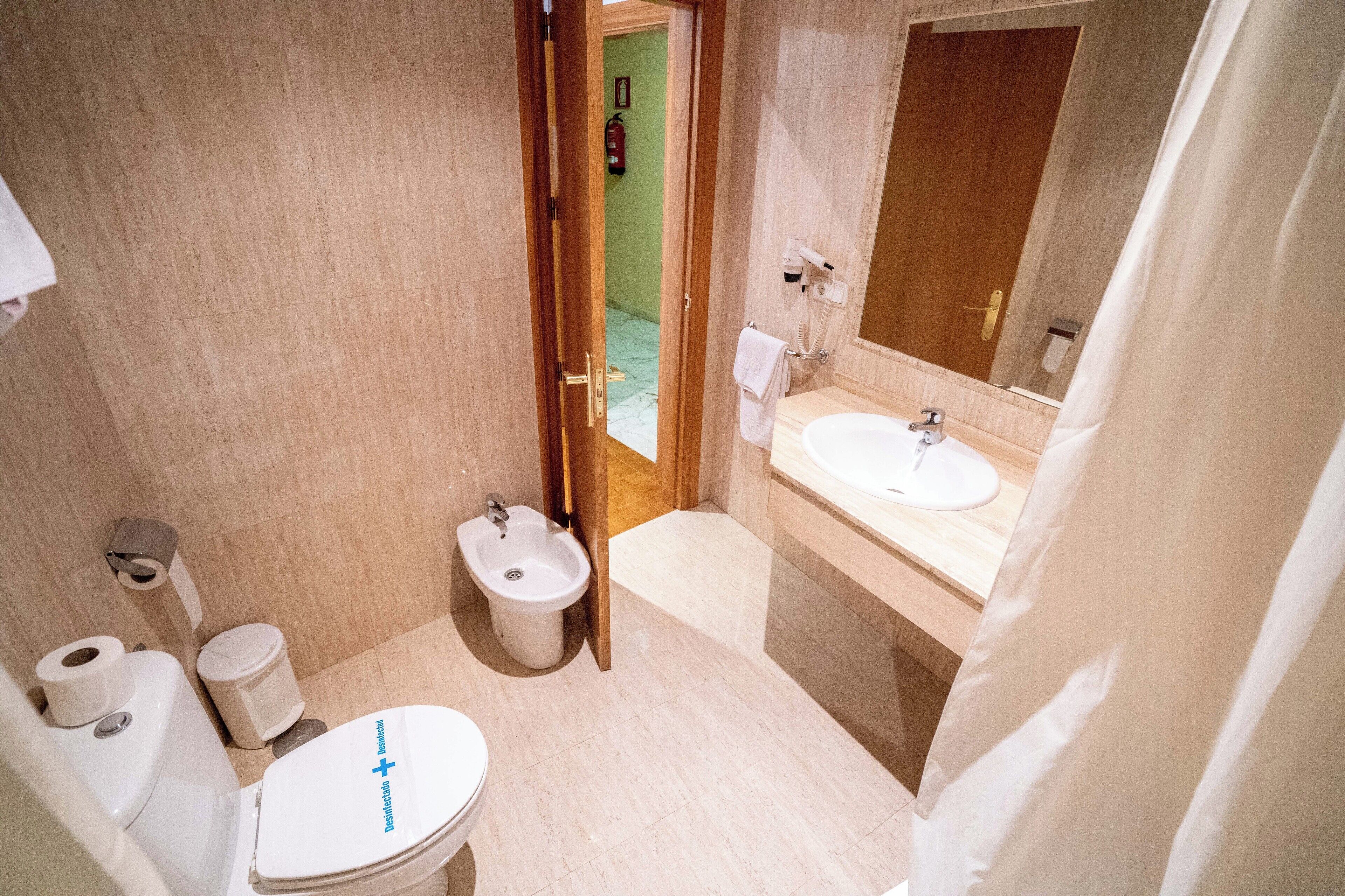 A small bathroom with a toilet, bidet, and sink.