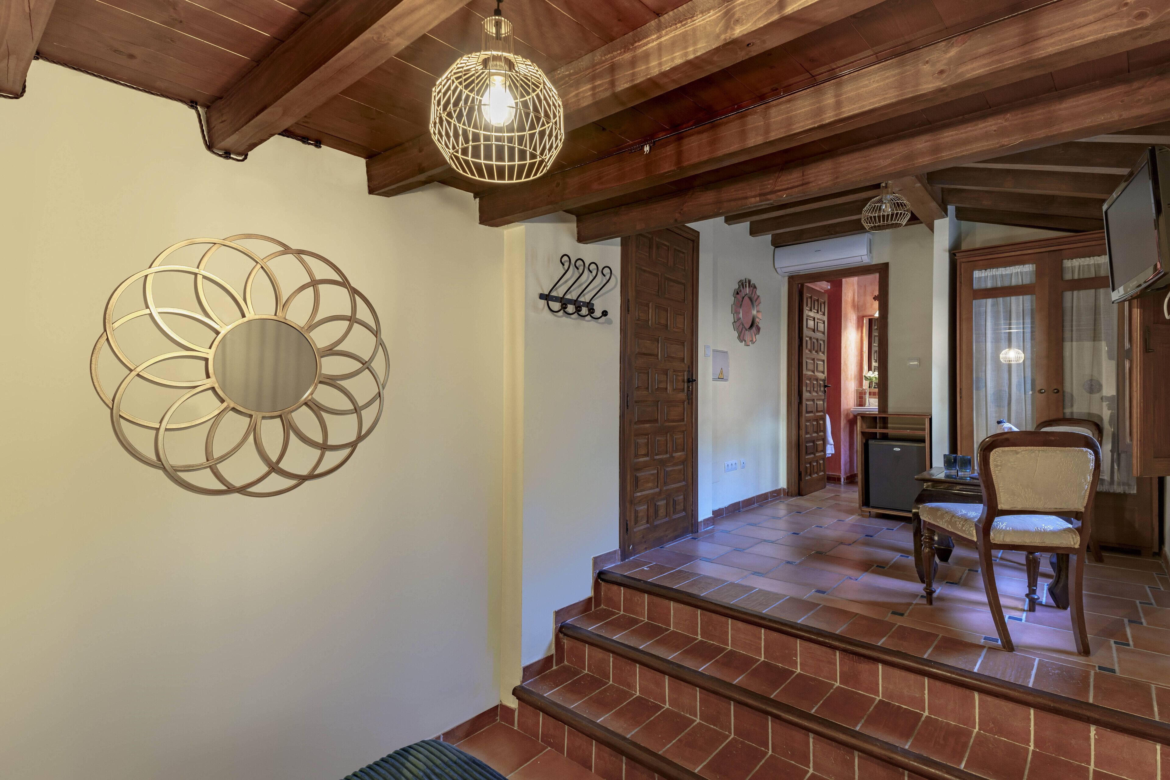 A staircase leading to a dining area with a wooden ceiling and a decorative wall piece.