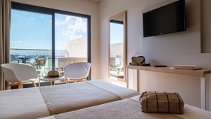 A hotel room with a bed, a TV, a desk with a chair, and a balcony with a table and chairs. - California Garden (Salou)