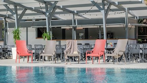 A poolside area with lounge chairs and a covered seating area. - California Garden (Salou)