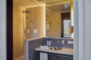 Une salle de bain moderne avec une douche, un lavabo et un miroir.