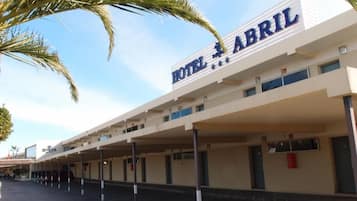 Hotel 'Hotel Abril', con estacionamiento cubierto y varios pisos.