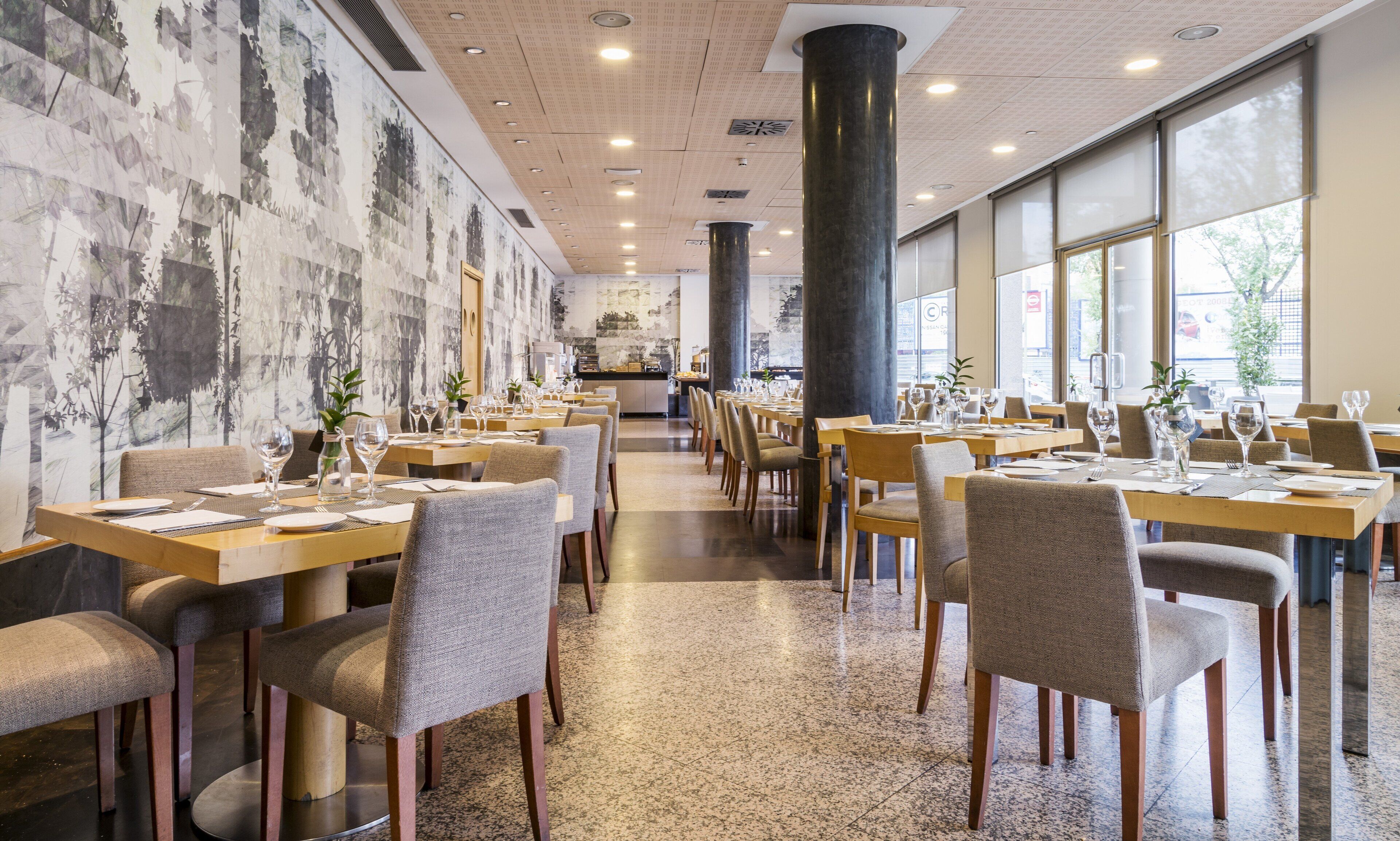 Un restaurante con varias mesas, sillas y una decoración interior moderna.