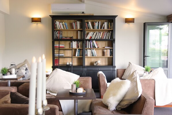 Una sala de estar acogedora con una estantería, sofás y una mesa de centro.
