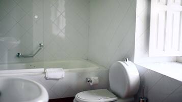 A bathroom with a toilet, sink, and bathtub.
