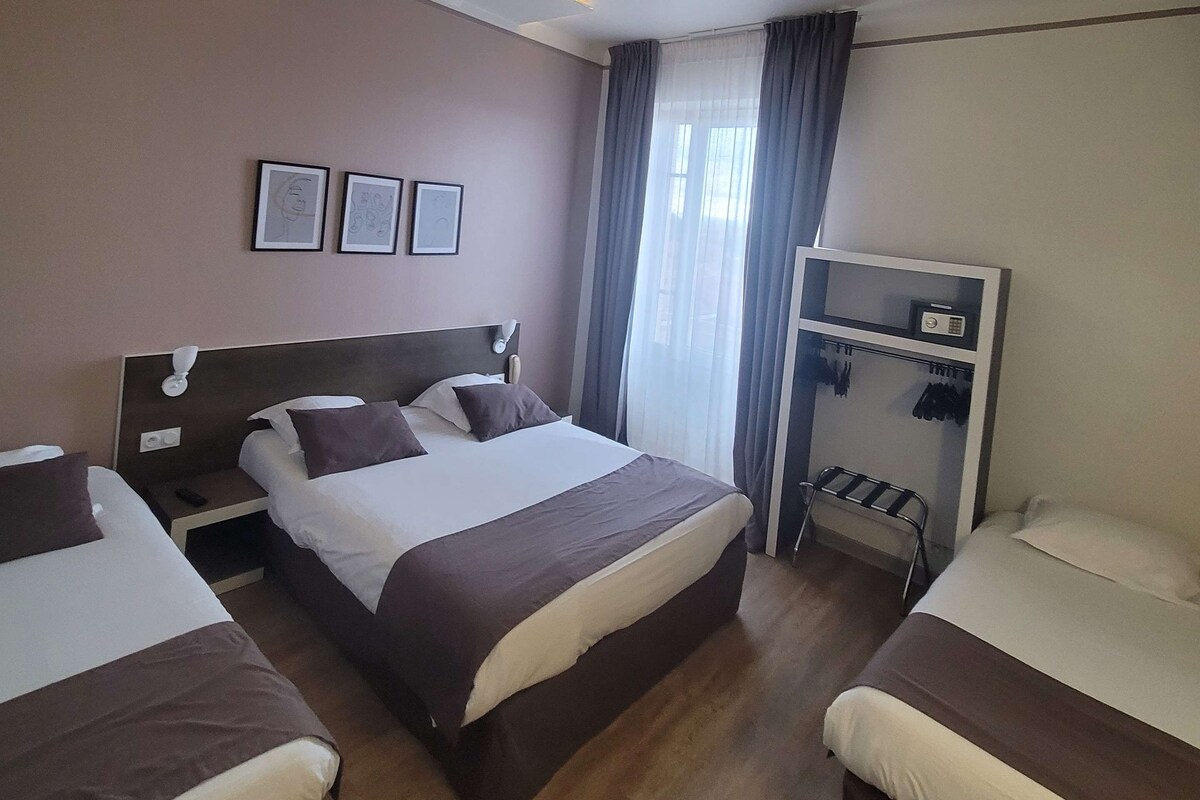 Una habitación de hotel con dos camas, un armario y un escritorio.