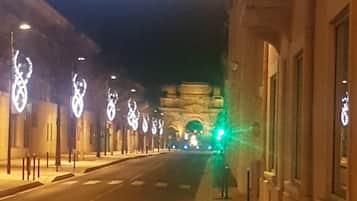 A street at night with illuminated decorations and a green traffic light.