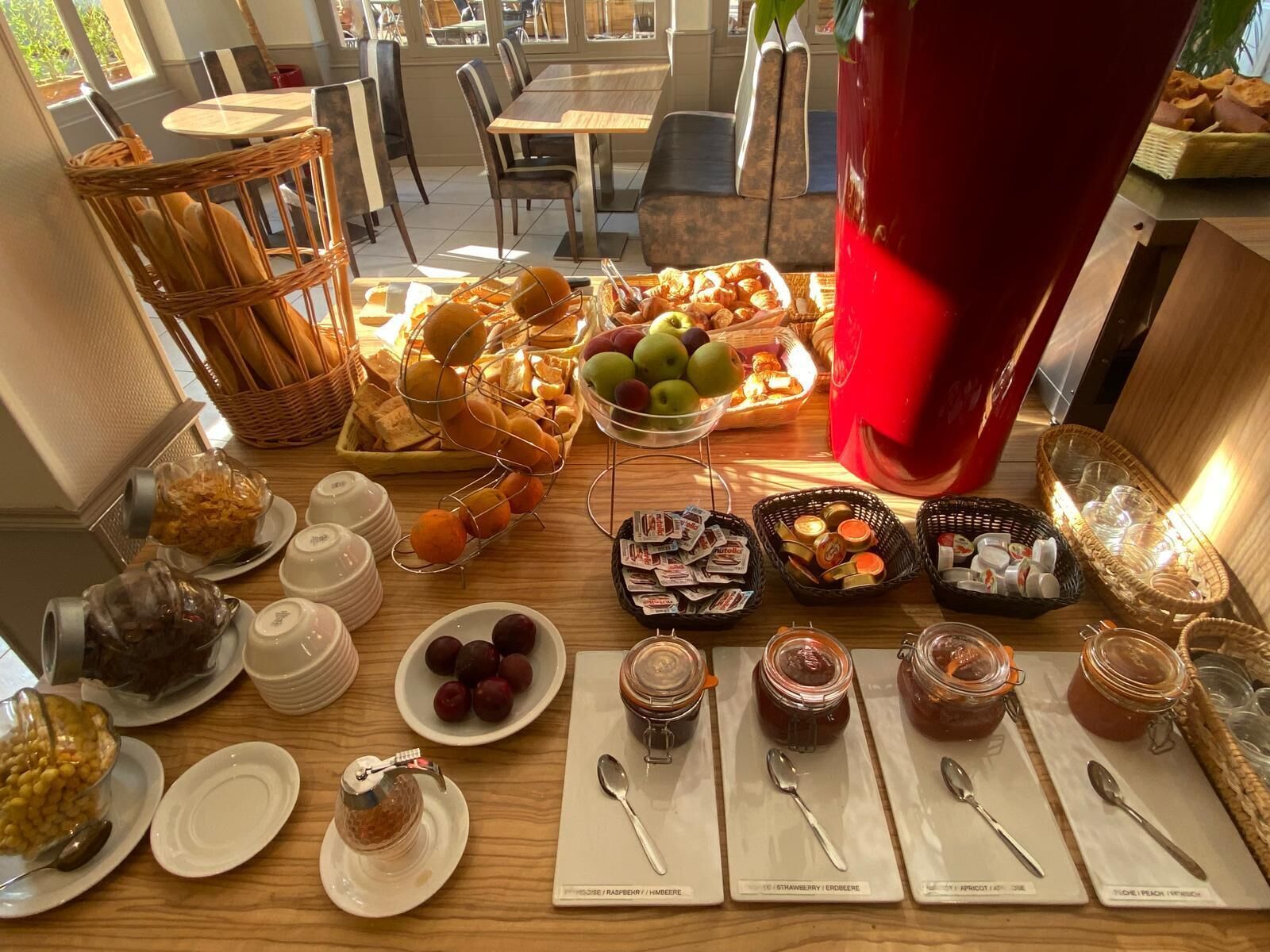 A breakfast buffet with various fruits, pastries, and spreads.