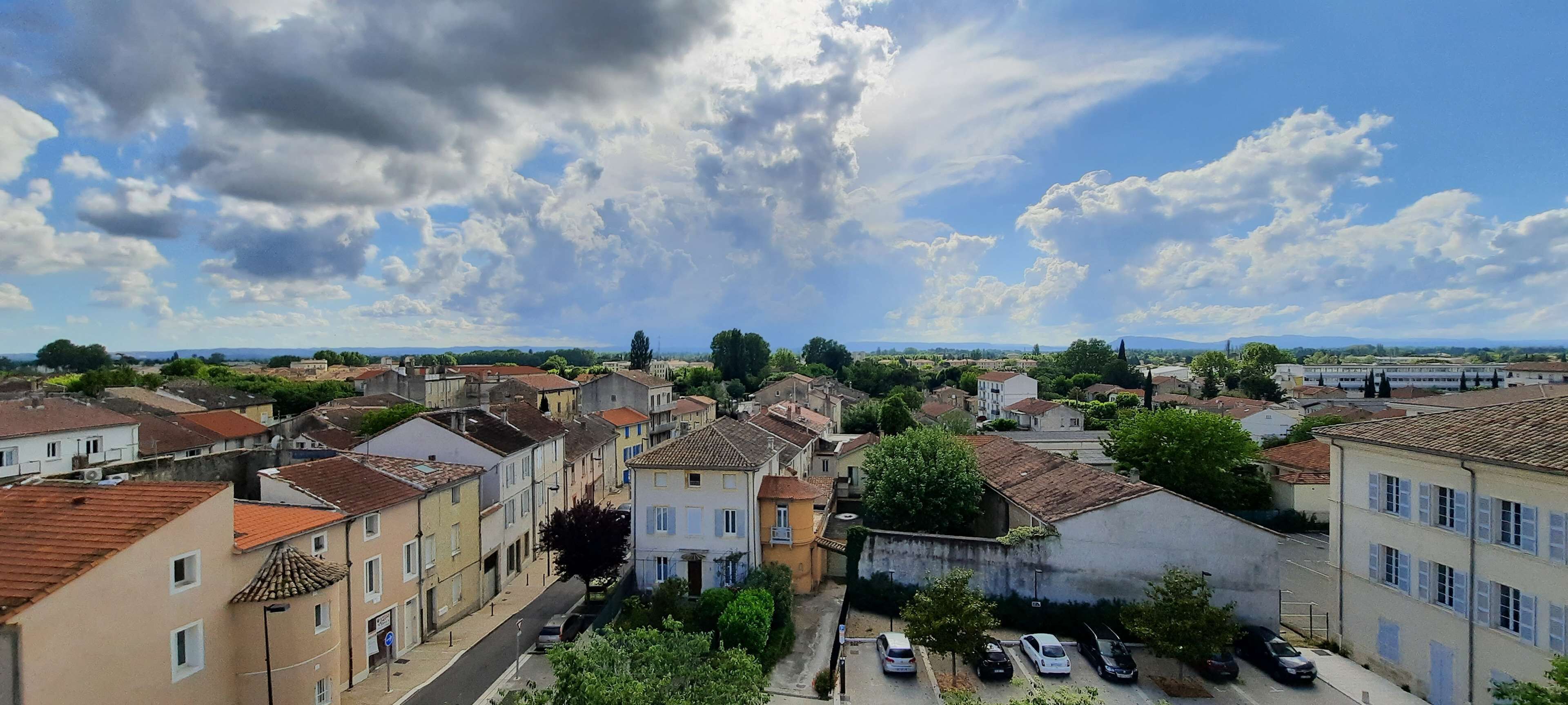A residential area with buildings, a street, and parked cars.