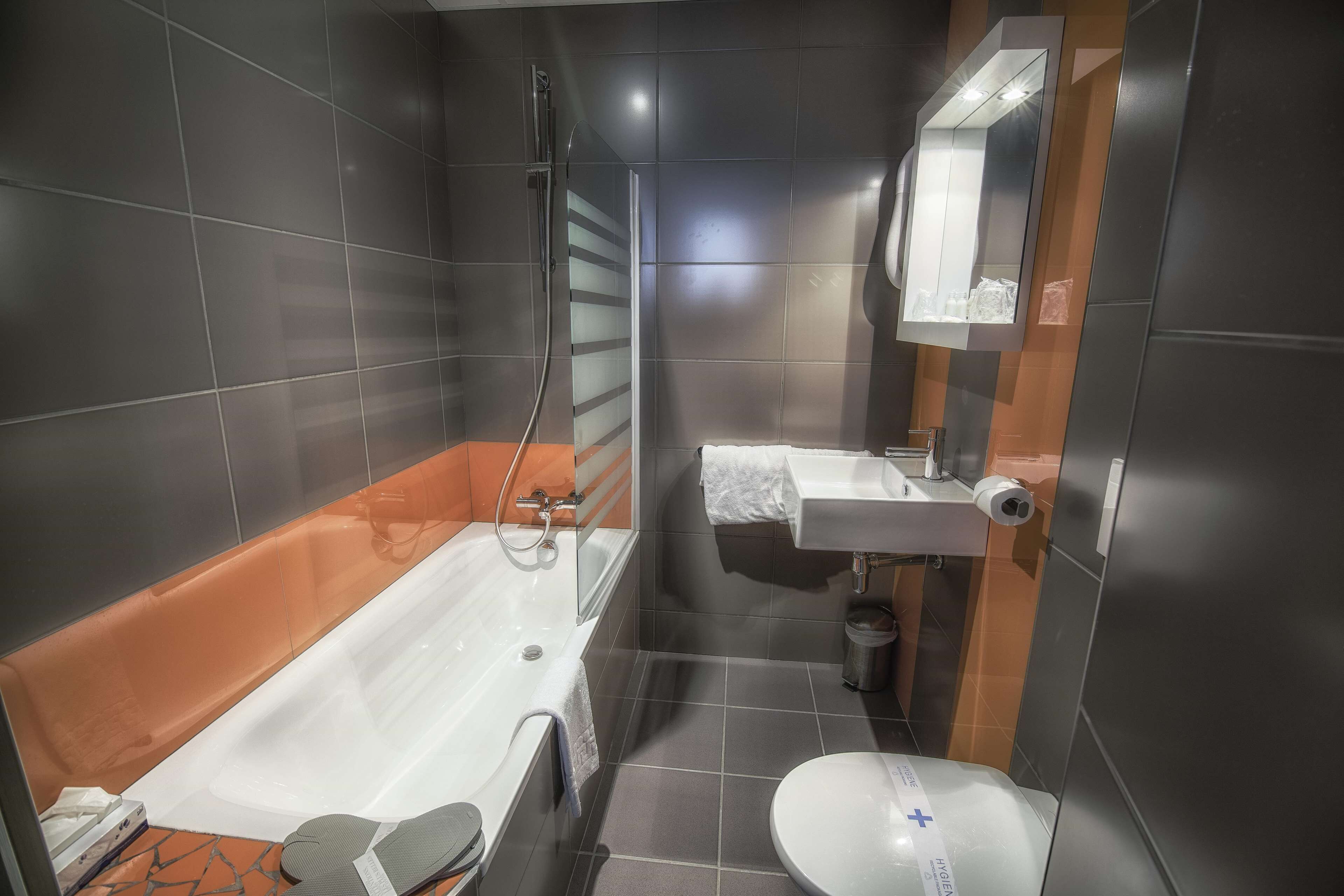 A modern bathroom with a bathtub, toilet, and sink.