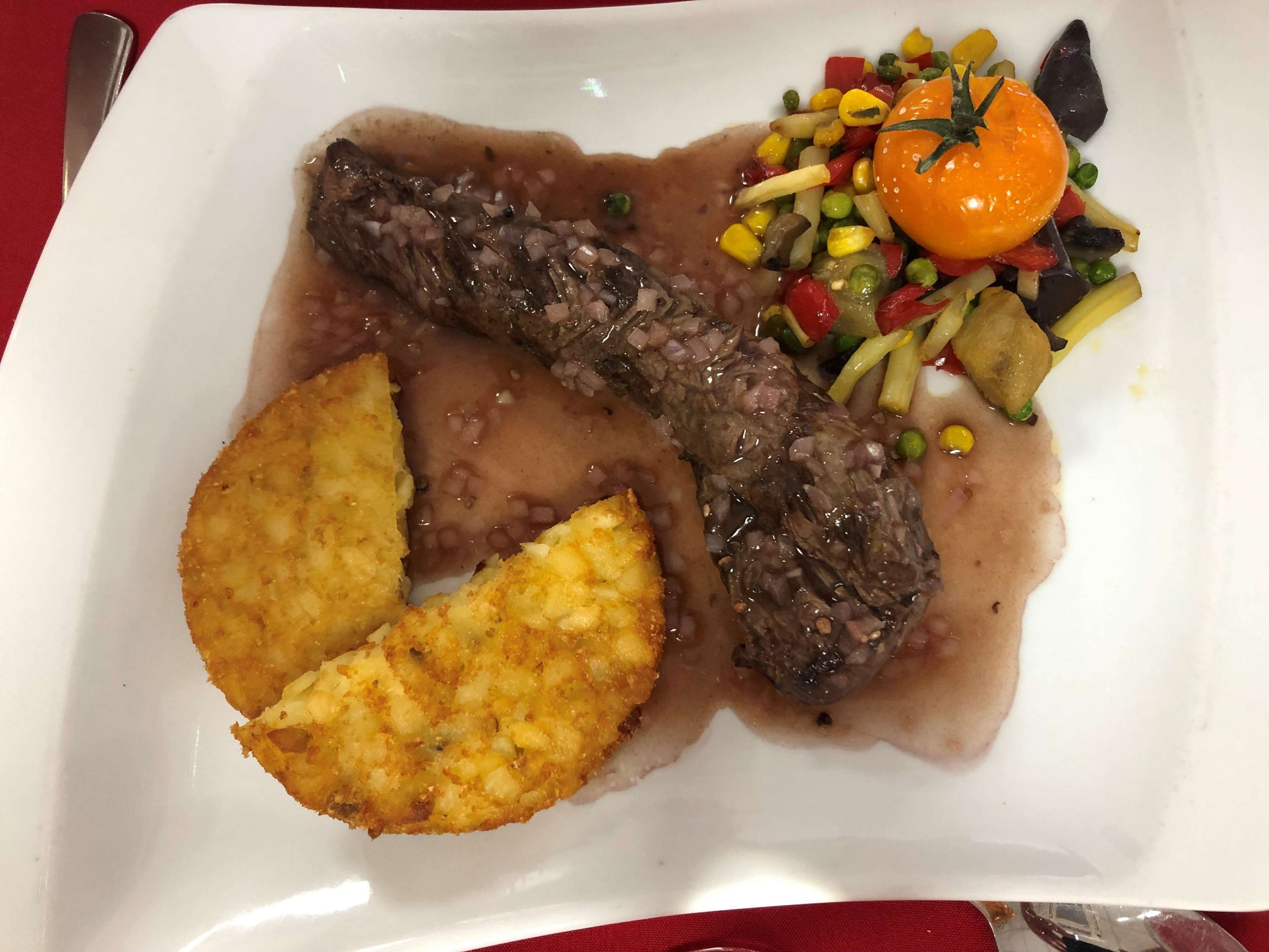 A plate with a meat dish, mashed potatoes, and a vegetable side.