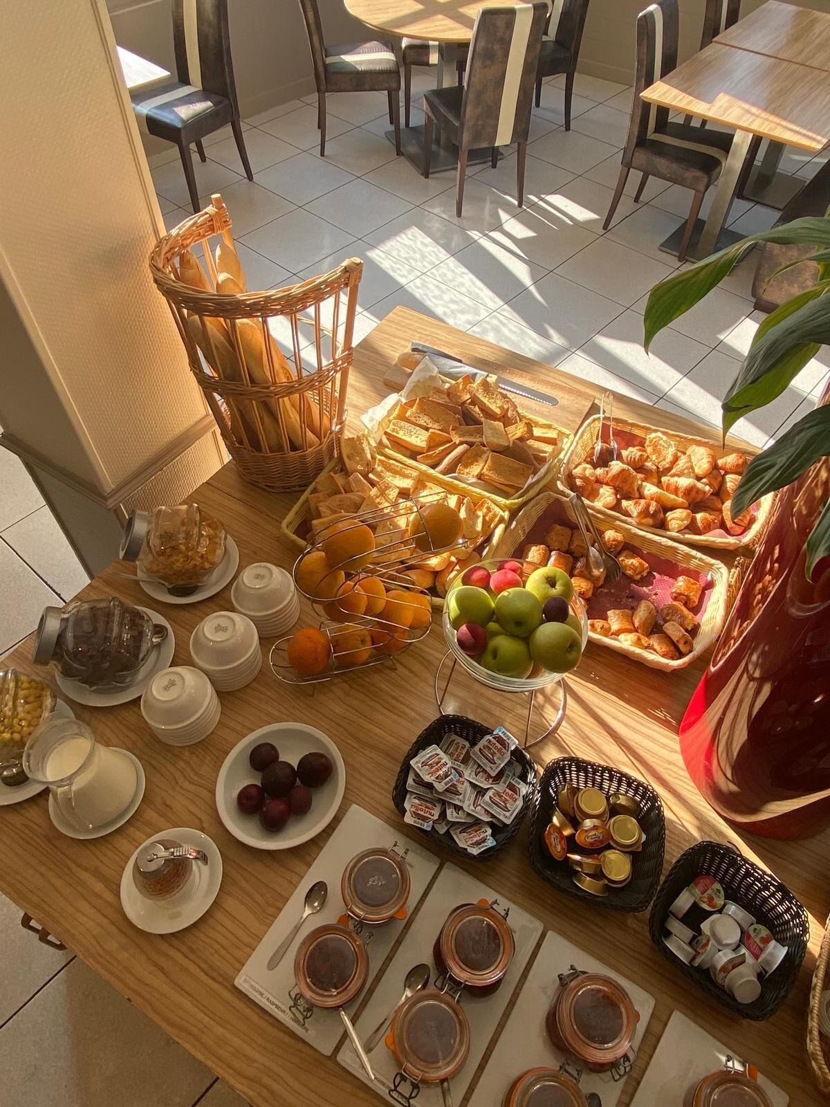 A breakfast buffet with various food items, including fruits, pastries, and condiments.