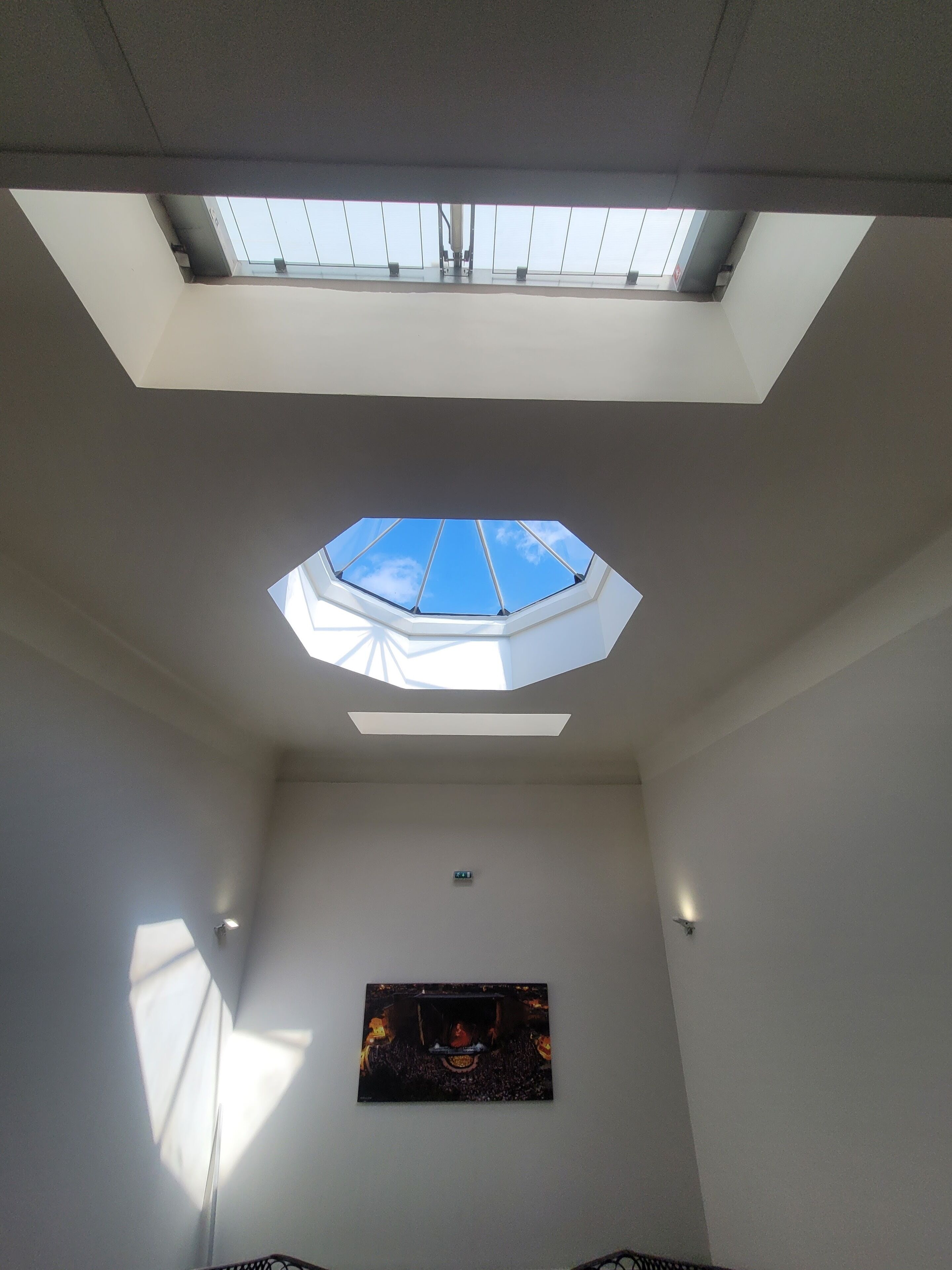 A room with a skylight and a flat-screen TV mounted on the wall.