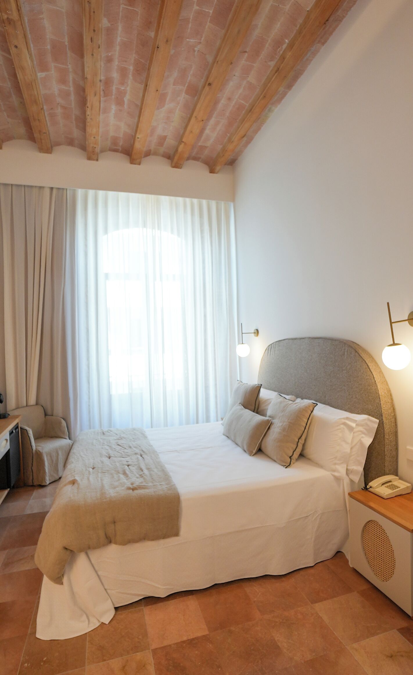 Un dormitorio con una cama grande, un escritorio y una silla.