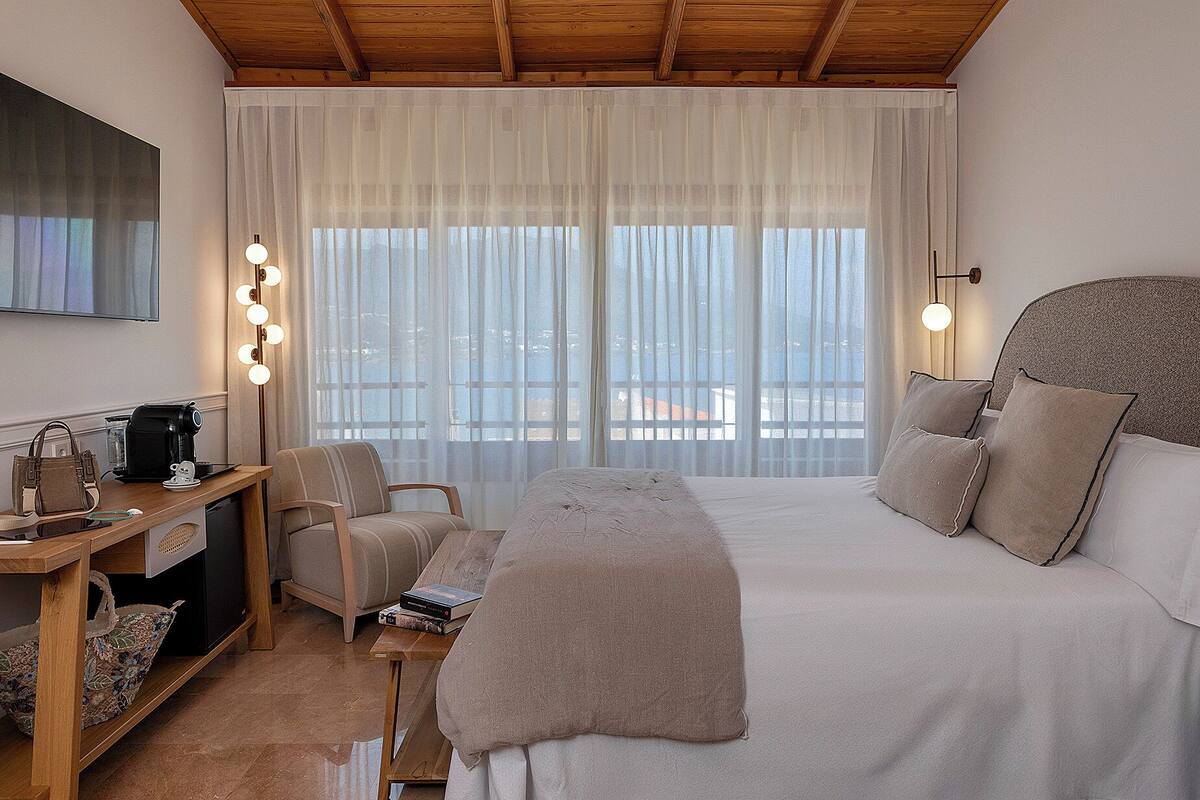 Une chambre d’hôtel équipée d’un lit, d’un bureau avec une machine à café, d’une chaise et d’un téléviseur.