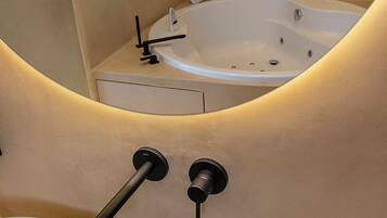 A bathroom with a bathtub, a sink, and a towel rack.