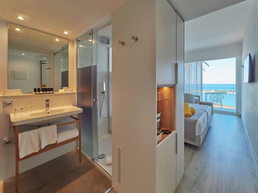 Une salle de bain moderne avec une douche à parois de verre, un meuble-lavabo avec un miroir et une baignoire.