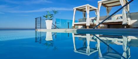 Piscine extérieure, parasols de plage, chaises longues