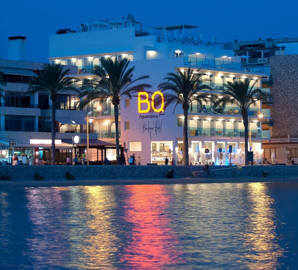 A hotel with a prominent 'BO' sign, multiple balconies, and a waterfront view.