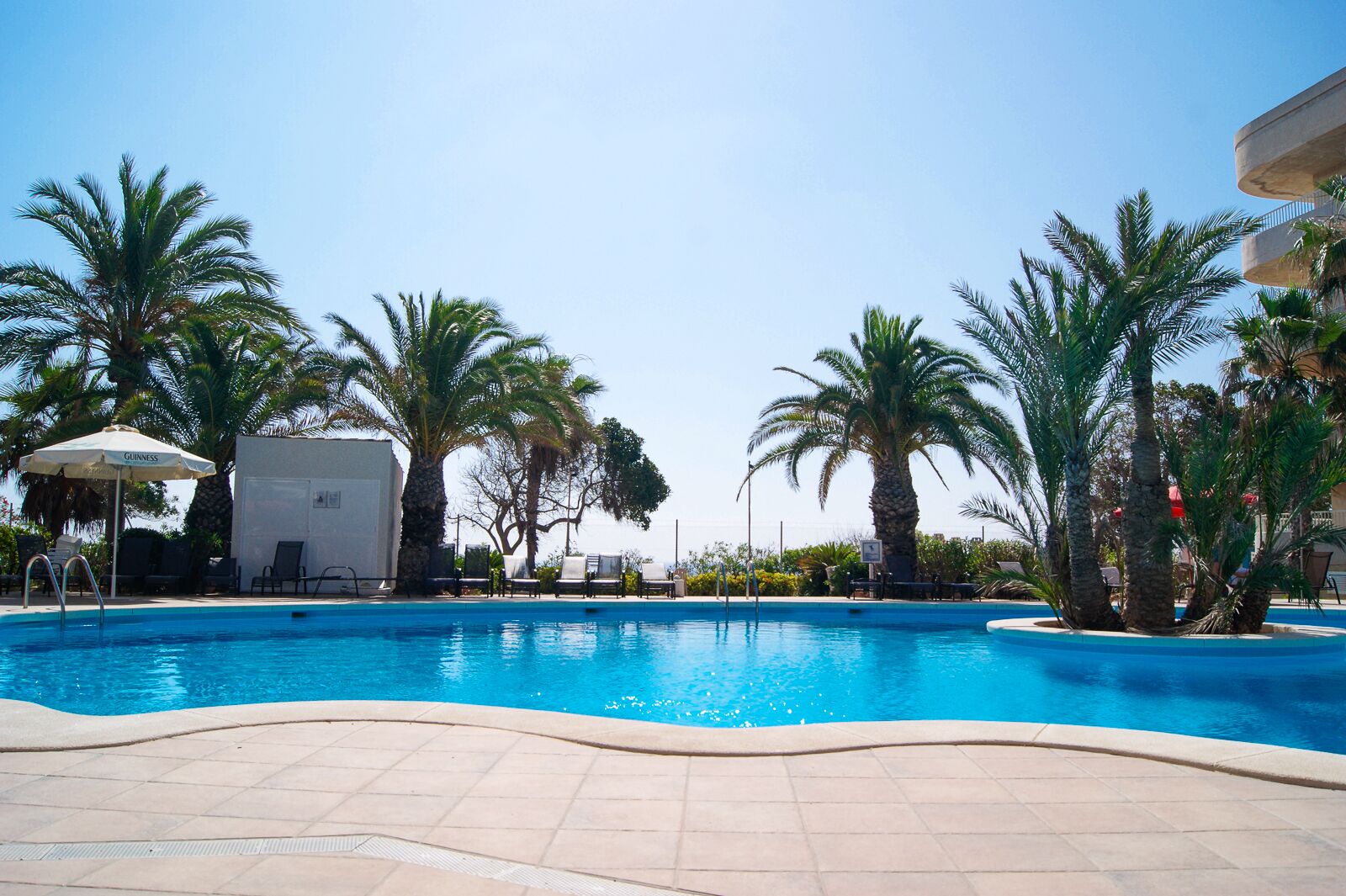 Una piscina al aire libre de temporada, tumbonas
