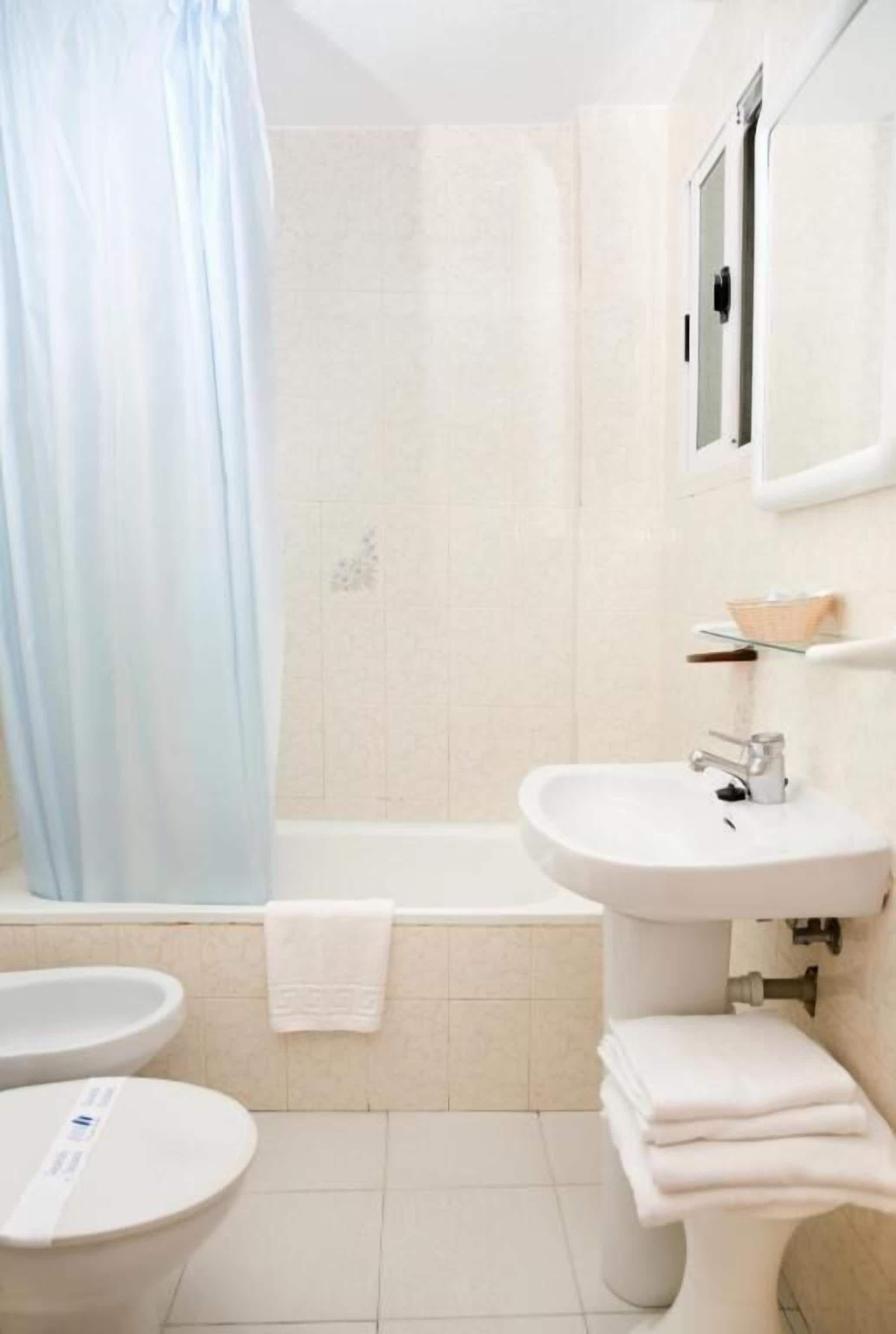 A bathroom with a bathtub, a sink, and a toilet.