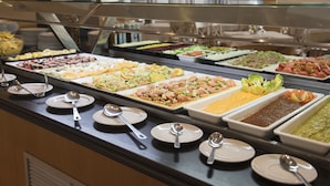 Un bufé con diversas opciones de comida y utensilios para servir.