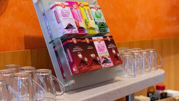 A display of tea boxes and empty glass mugs on a countertop.