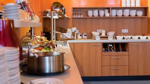 A buffet area with various food items and utensils. - Hotel Europa (Görlitz)