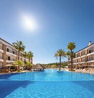 Una piscina techada, una piscina al aire libre, sombrillas