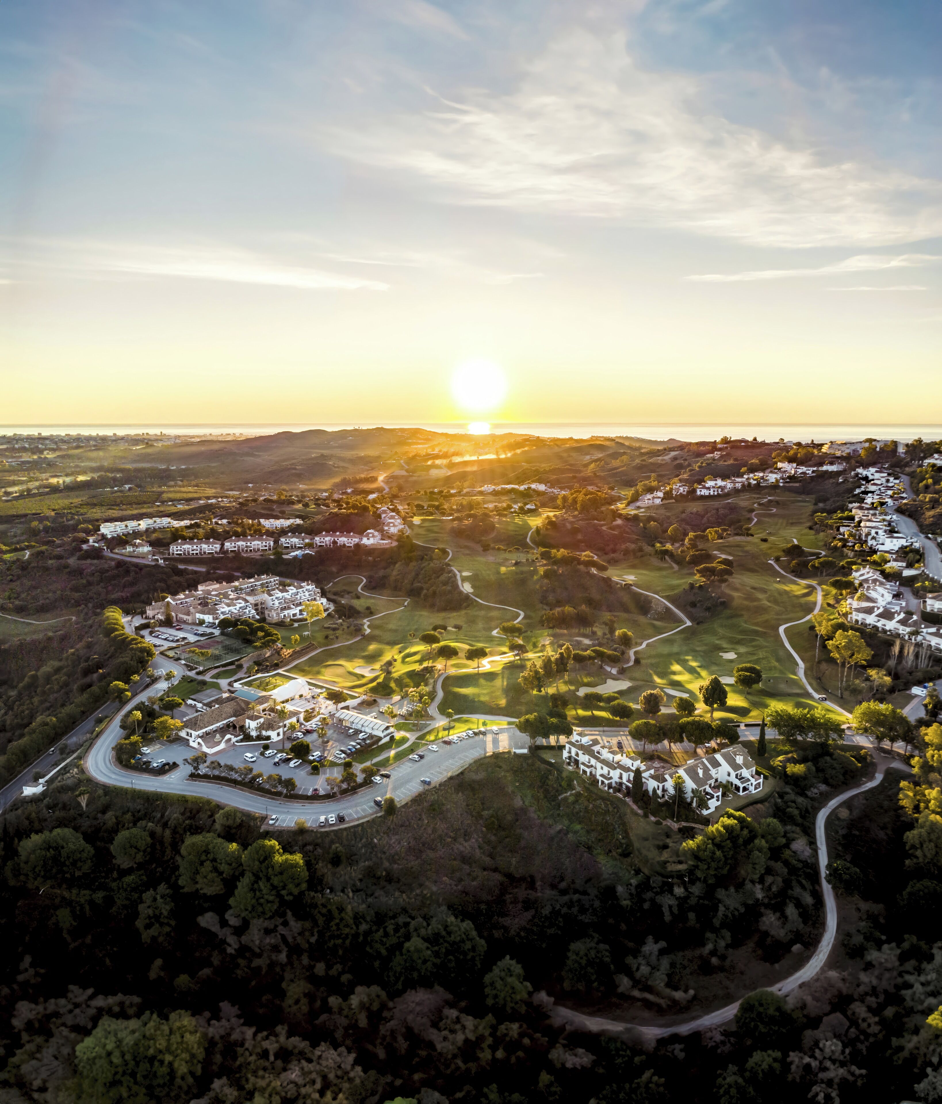 Vue aérienne d’un quartier résidentiel avec des maisons, des routes et des espaces verts.
