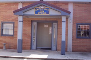 Un edificio de ladrillo con un letrero que dice 'Executive Inn Office'.