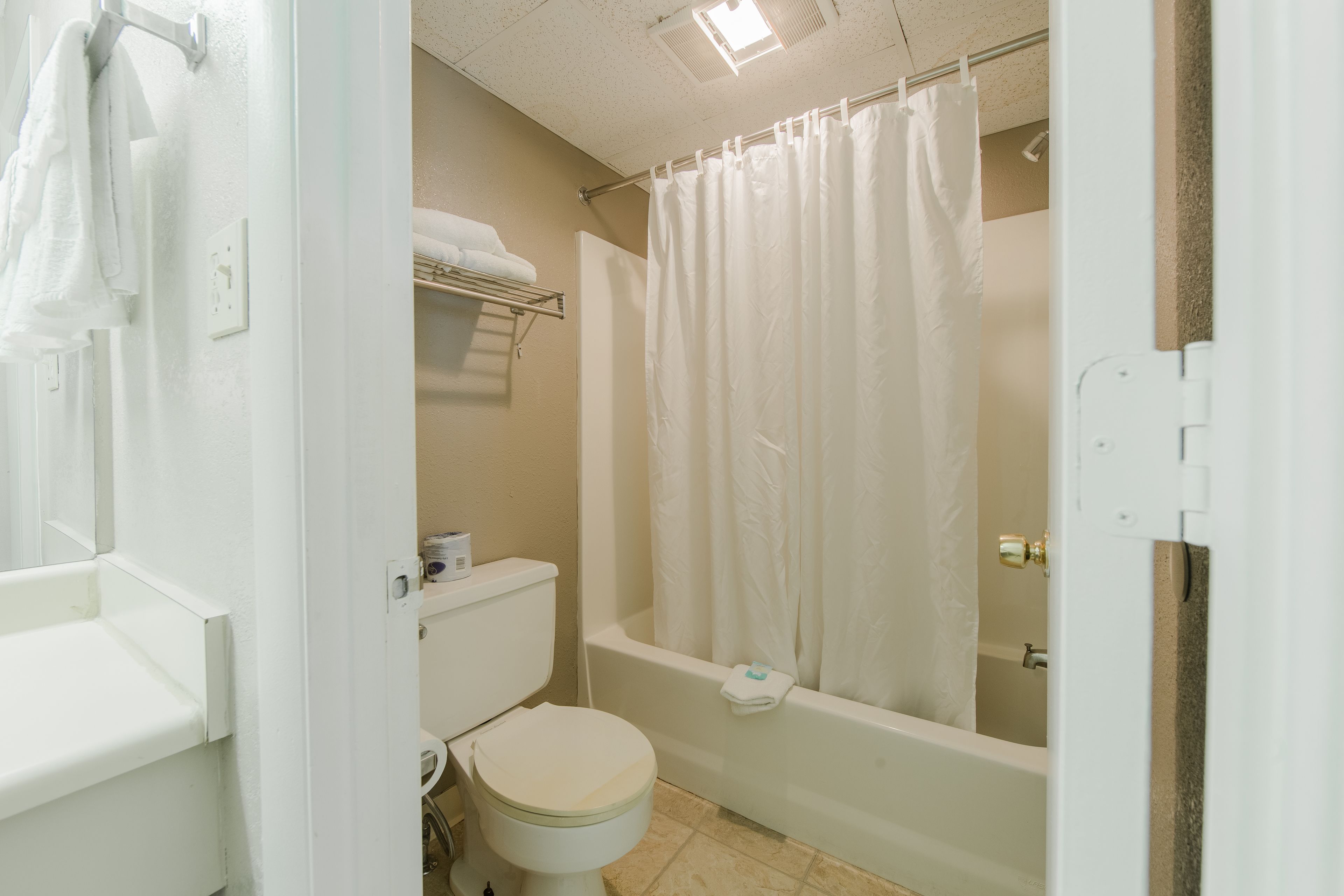 A bathroom with a toilet, bathtub, and shower curtain.