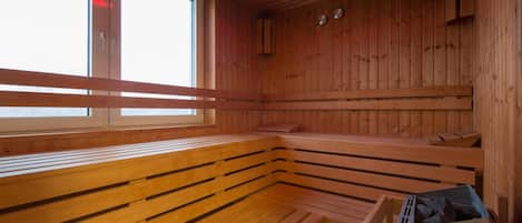 Una sauna con bancos de madera y una ventana.