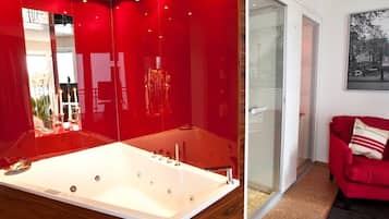 Een moderne badkamer met een groot bad, een douchecabine van glas en een rode bank in de aangrenzende woonkamer.