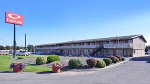 A motel with a sign reading 'EconoLodge,' a parking lot, and a building with a balcony. - Econo Lodge Kennewick Tri-Cities (Kennewick)