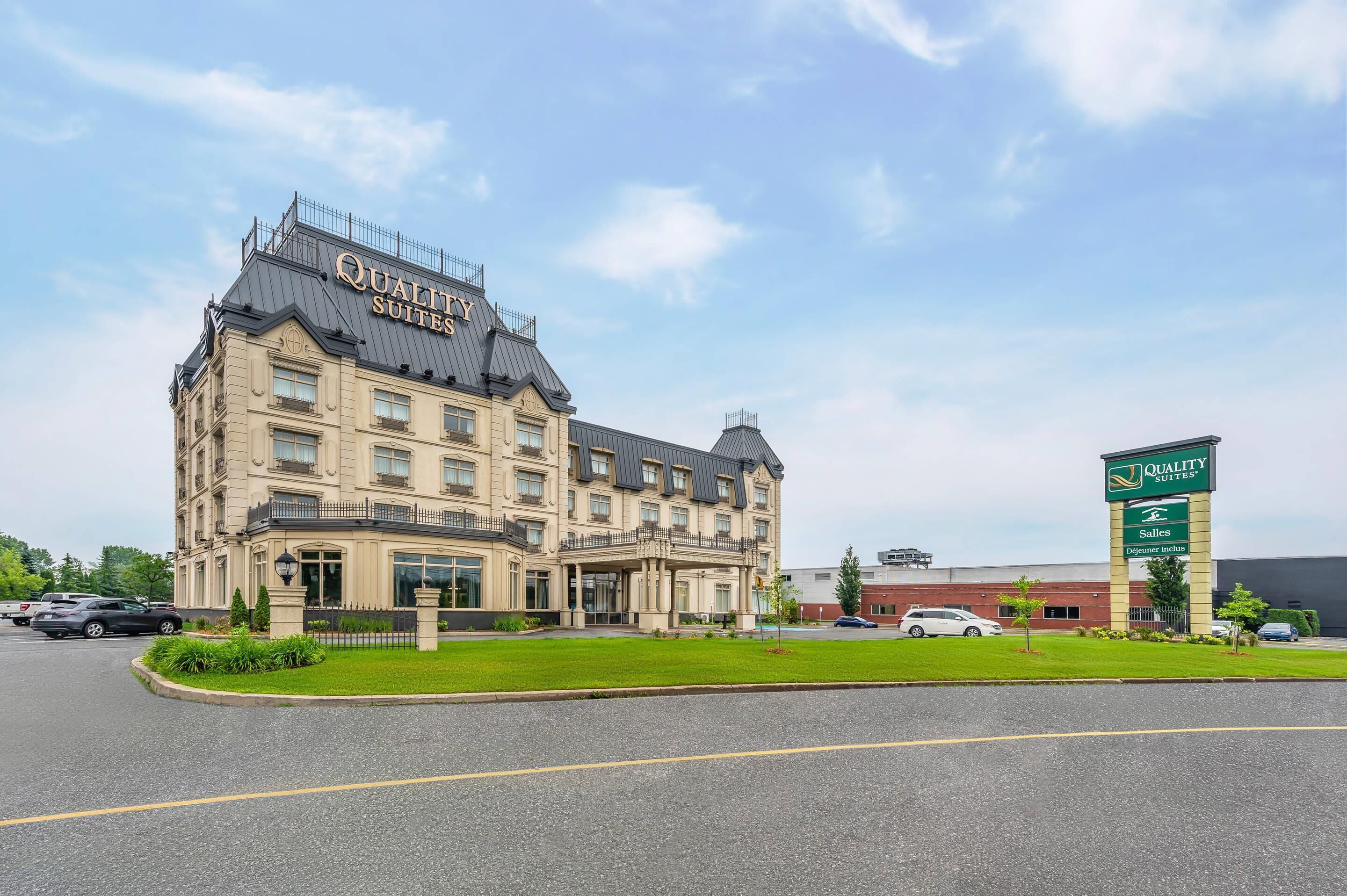 Un gran edificio de hotel con un letrero que dice 'Quality Suites'.