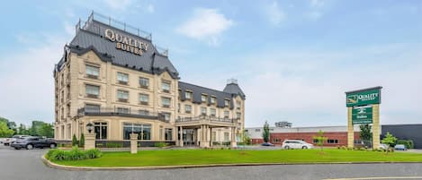 Un gran edificio de hotel con un letrero que dice 'Quality Suites'.