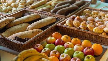 Verschiedene Brotsorten und Früchte in Körben präsentiert.