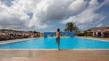 Een binnenzwembad, een buitenzwembad, parasols voor strand/zwembad