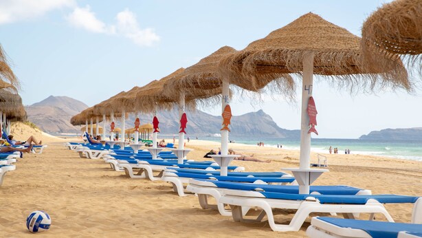 A beach with rows of sun loungers and thatched umbrellas. - Vila Baleira Porto Santo (Porto Santo)