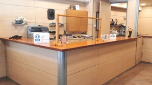 Un mostrador de recepción con encimera de madera, un teléfono y un cartel que indica la disponibilidad de WiFi.
