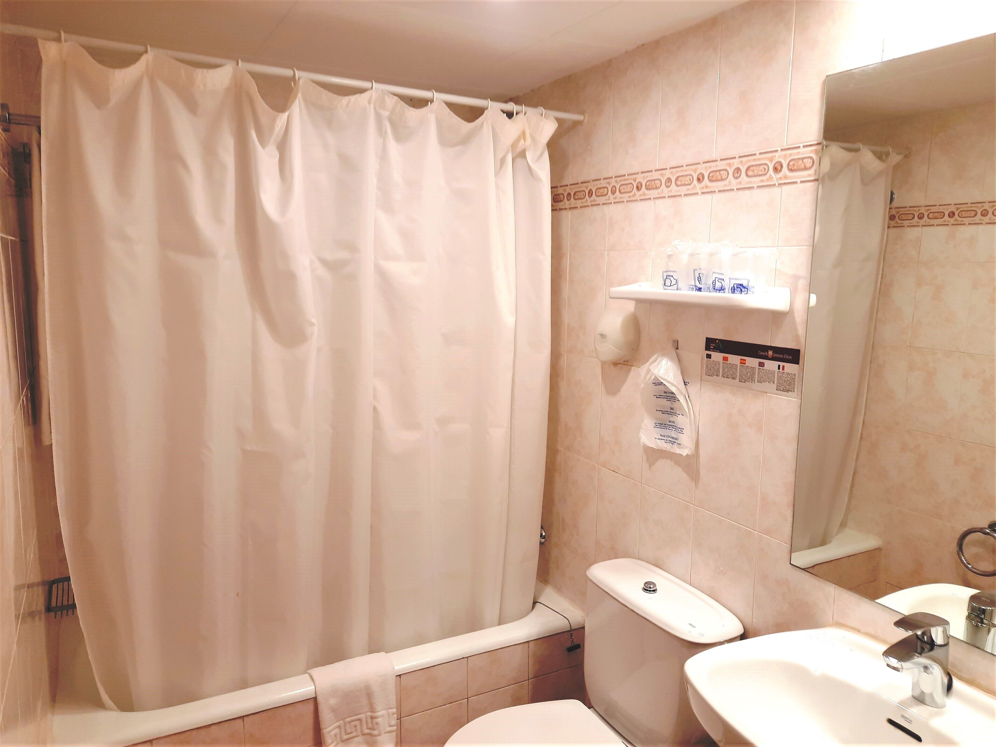Ein Badezimmer mit Badewanne, Toilette, Waschbecken und Spiegel.