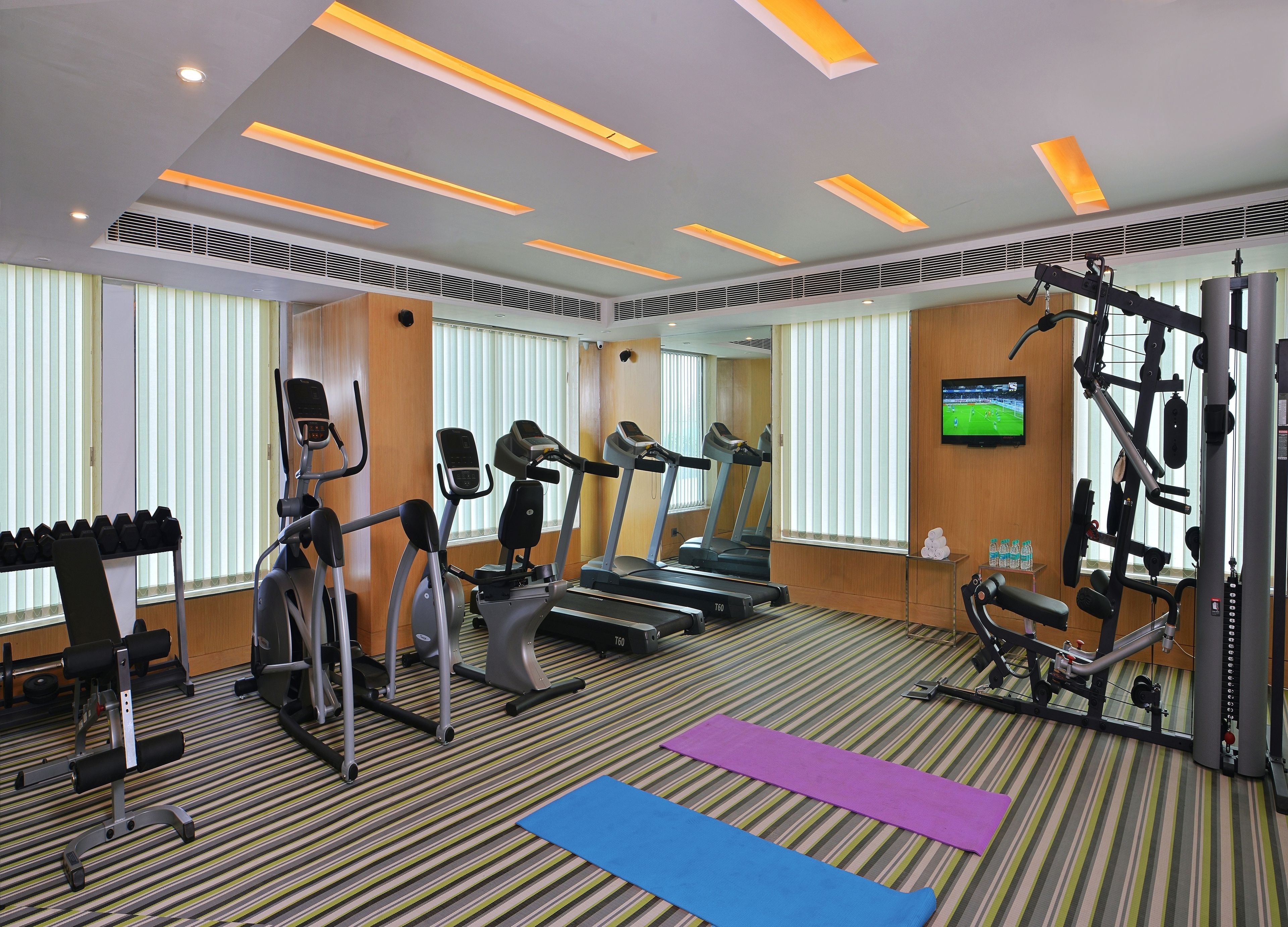 A gym with treadmills, elliptical machines, and weight equipment.